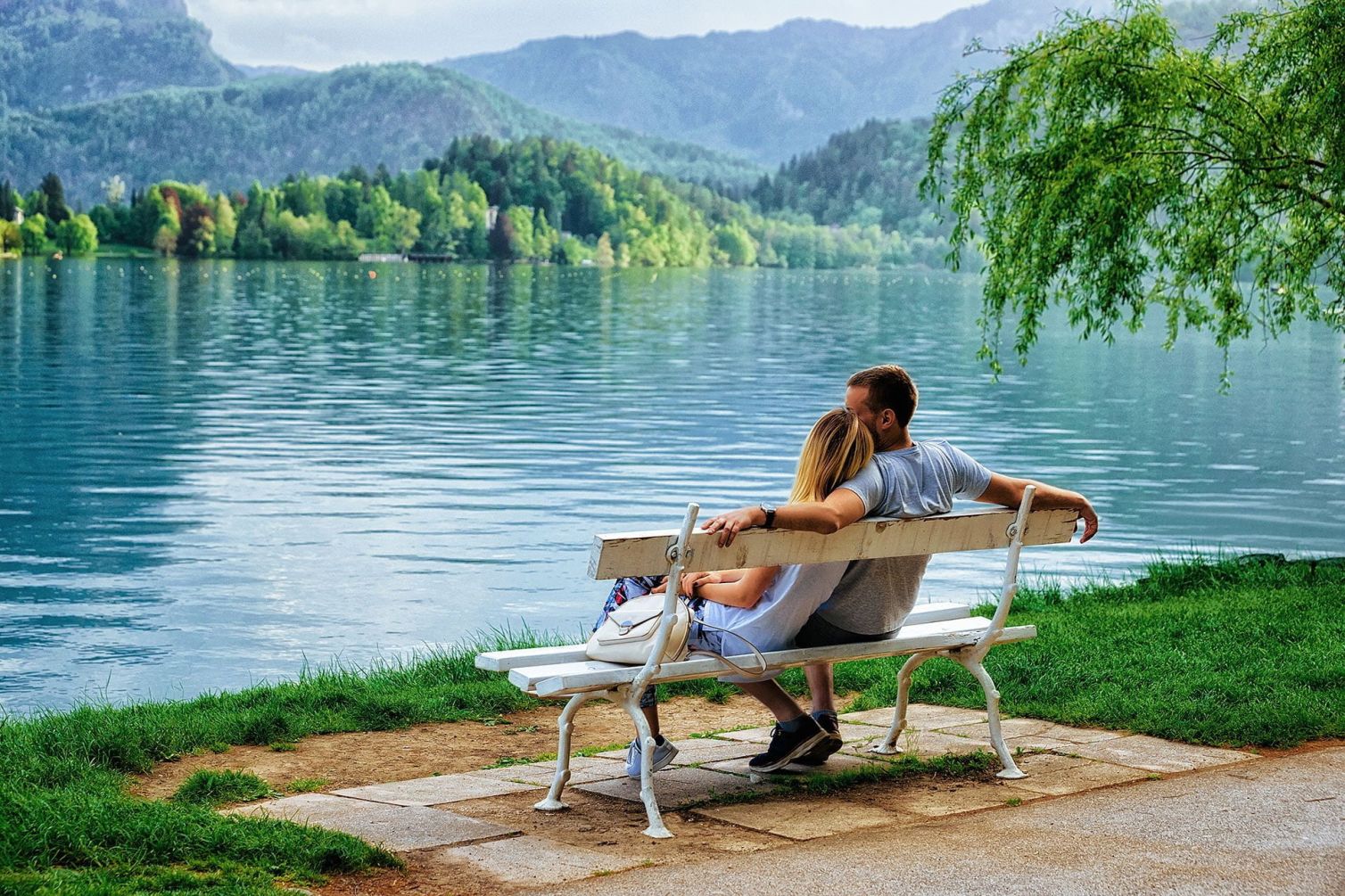 romantic-couple-sitting-bench-bled-lake-slovenia.jpg